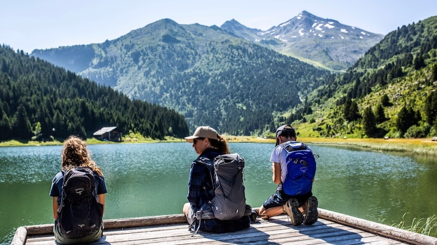 Trois personnes assises au bord de l'eau dans les 3 Vallées