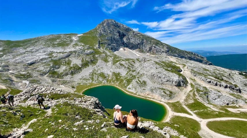 Deux personnes assises dans la montagne devant le lac de la Grande Moucherolle